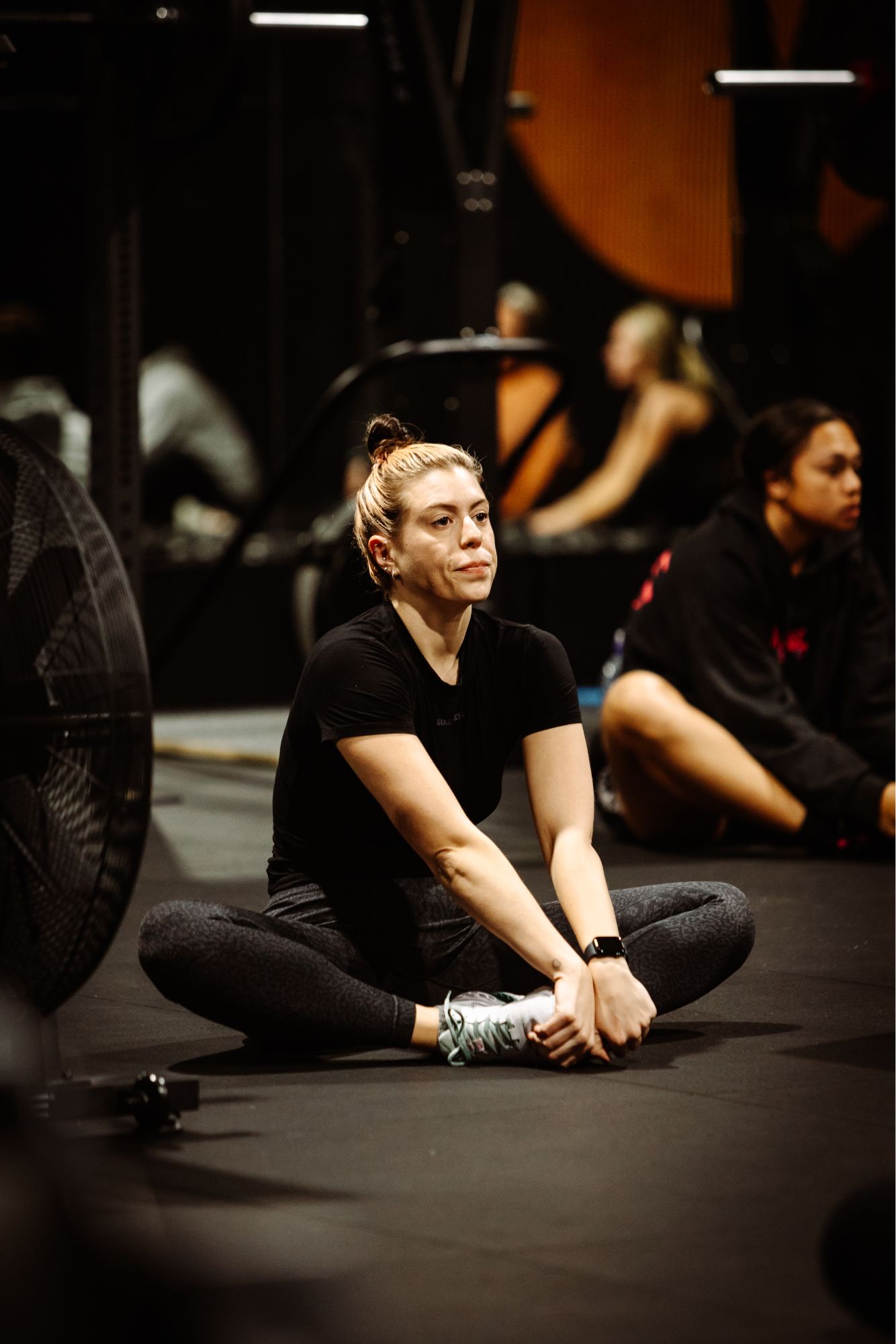 lady sitting on floor of gym class balance twenty one training