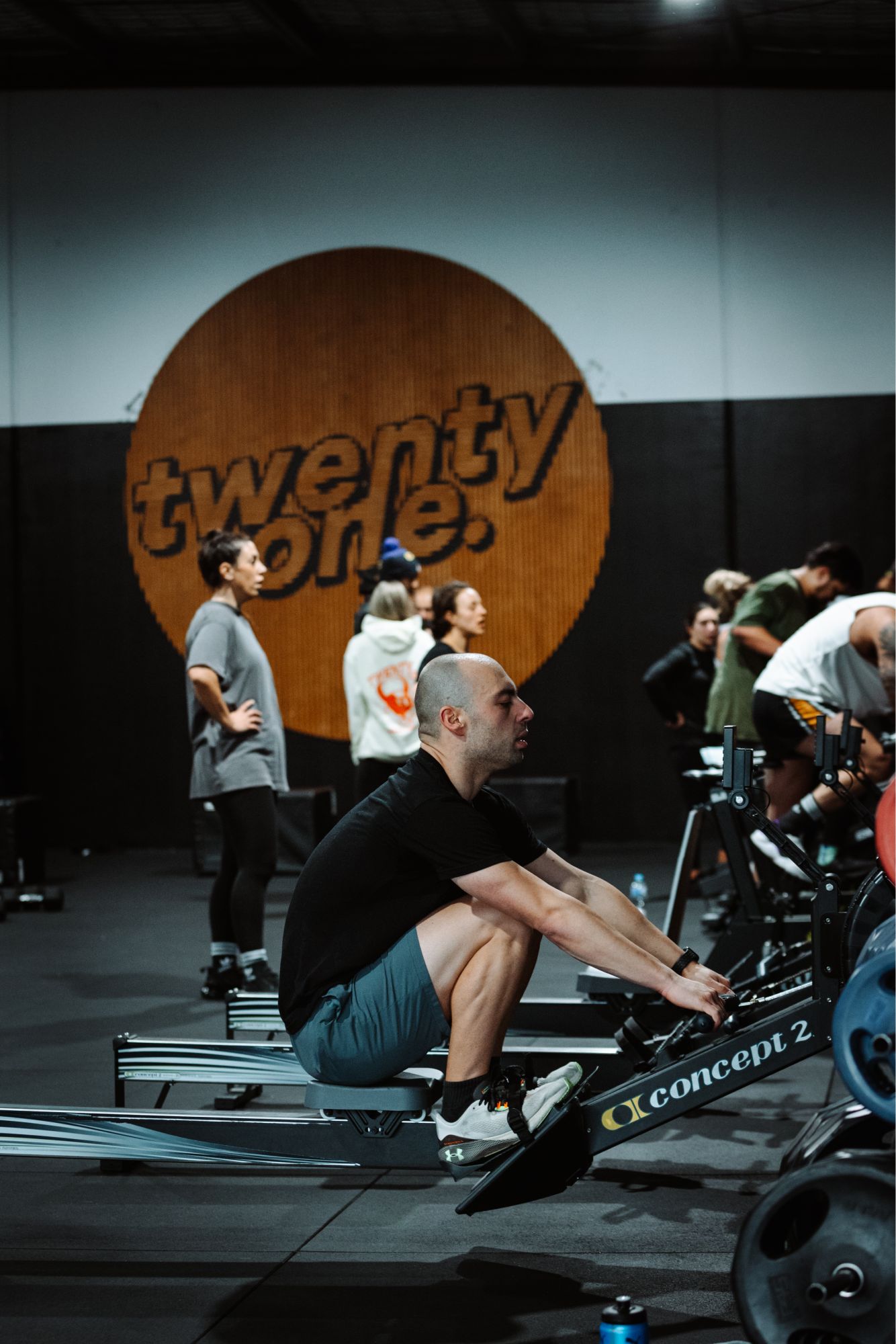 man on rowing machine in gym class heat twenty one training