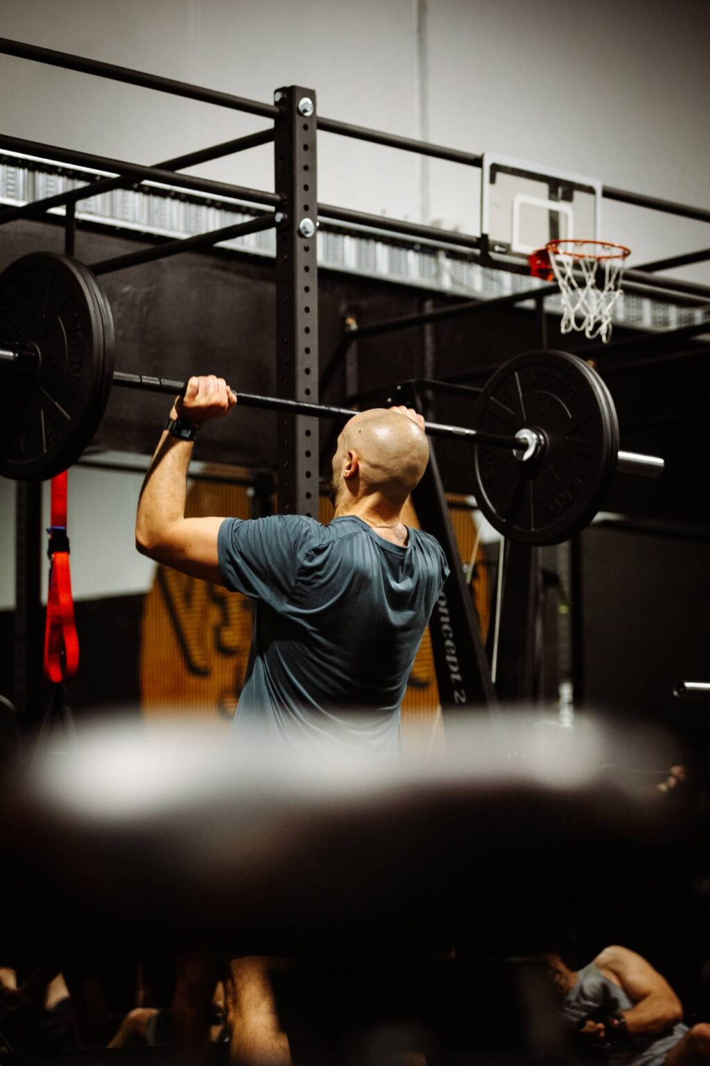 man lifting barbell weights for shoulder press at Twenty One Training gym in Airport West