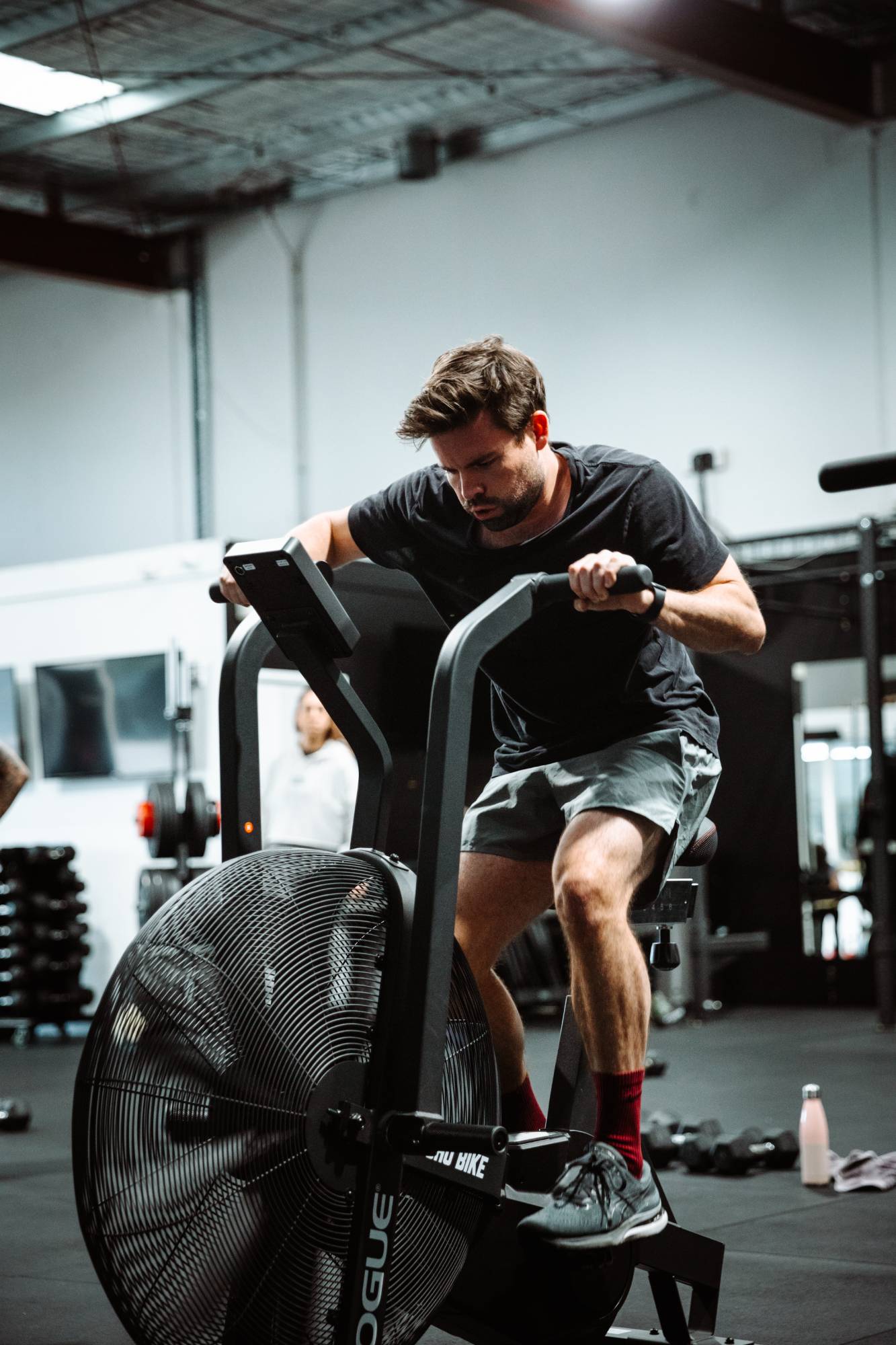 Man cycling on assault bike in Twenty One Training Gym in Airport West