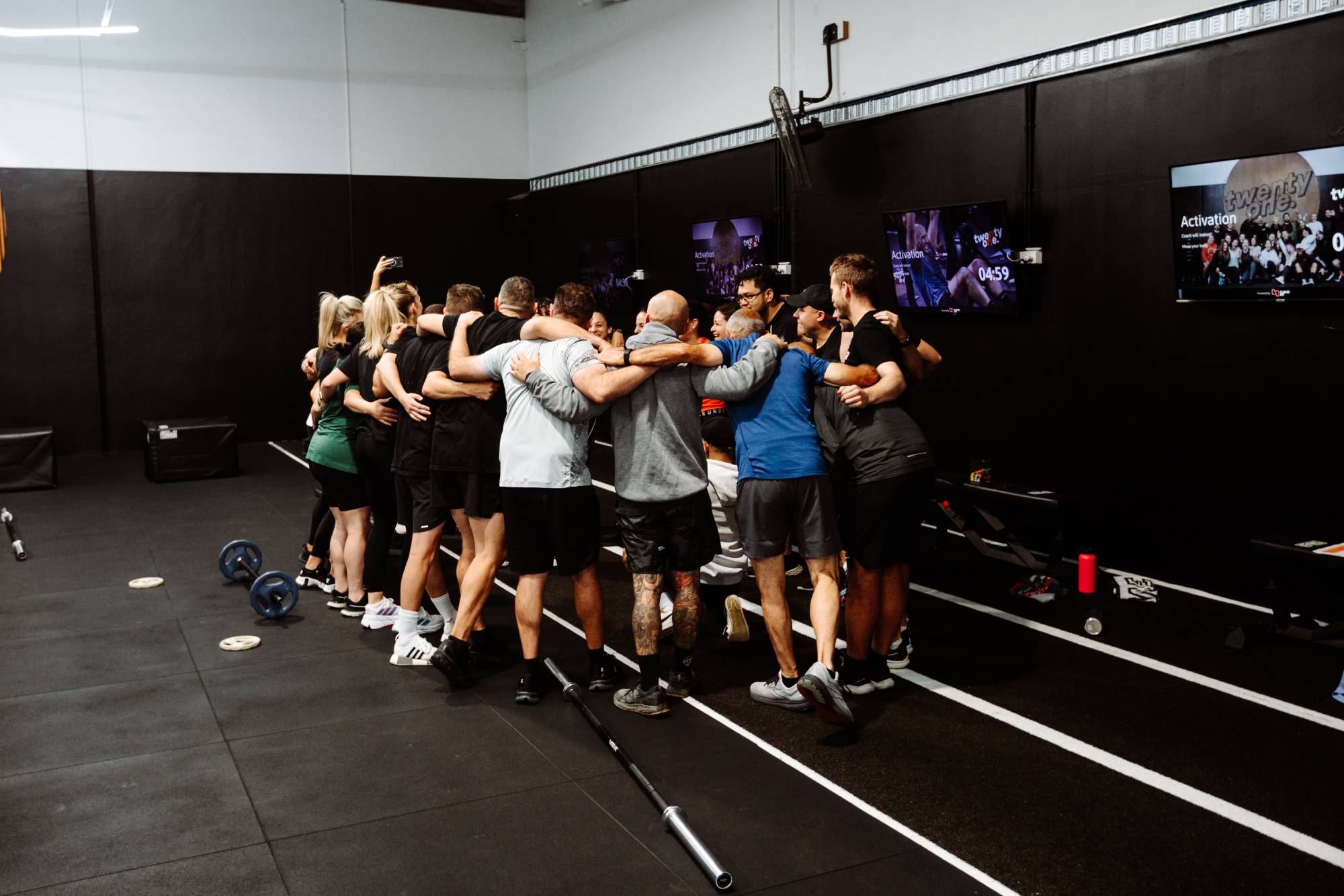 People group hugging in fitness Twenty One Training gym in airport west